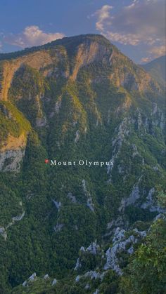 the mountains are covered in green trees and blue sky with clouds above them, as well as an inscription that reads mount glympur