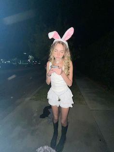 a girl in bunny ears looking at her cell phone