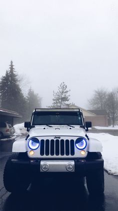 a white jeep is parked in the snow