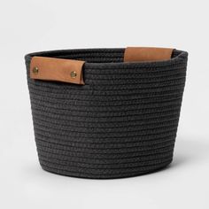 a large black and brown basket with leather handles