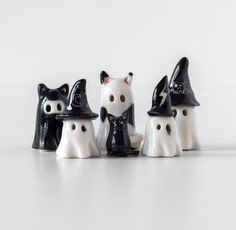 three black and white ceramic cats with witches hats