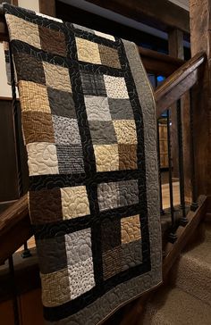 a black and white quilt hanging on a stair rail