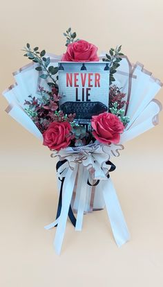 a bouquet of red roses in a gift box with a sign that says never lie