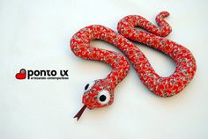 a red and white snake with black eyes on it's head is laying down