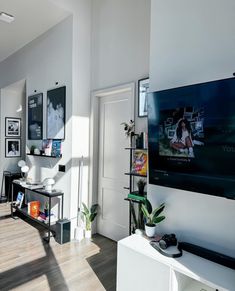 a living room filled with furniture and a flat screen tv mounted to the side of a wall