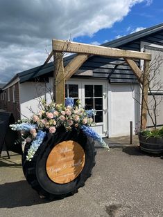 a large wooden barrel with flowers on the side and a sign that says welcome to our wedding