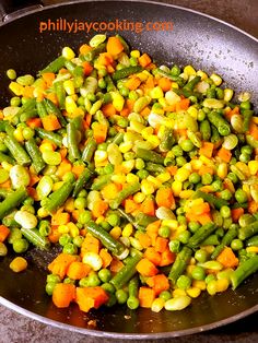 peas, carrots and corn cooking in a wok on the stove top for dinner