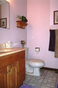 a bathroom with pink walls and tile flooring