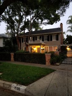 a house that is lit up at night with lights on the front and side windows