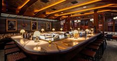 a large bar with lots of stools and lights on the counter top in a restaurant