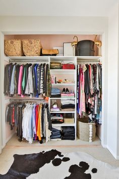 an organized closet with clothes, baskets and other items on shelves next to a cow rug