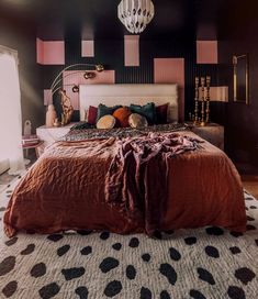 a bedroom with black and pink walls, polka dot rugs and a large bed