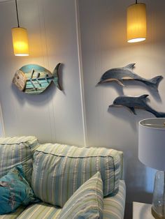 a living room filled with furniture and two fish mounted to the wall above it's head