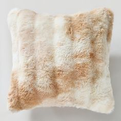 a white and brown pillow with fur on it