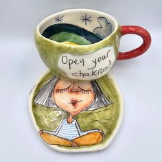 a ceramic cup with an image of a woman's face and words written on it