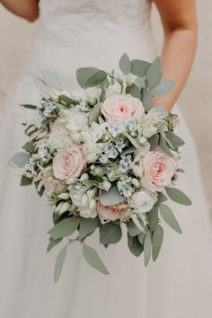 a bridal holding a bouquet of flowers and greenery