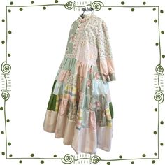 "This one of a kind, handmade, cottagecore dress is a boho coquette dream! It is a patchwork dress in pioneer, prairie dress style in summery cotton with a very full skirt, tiers and ruffles. Accented with floral appliques *Cool, lightweight cotton coquette style *Mismatched button front *Mismatched sleeves with contrasting interior look great rolled up *2 pockets *Upcycled boho patchwork  *Extremely flowy & twirly! *Whimsical cotton florals *Many, many details including mismatched roll up cuffs Patchwork Quilt Dress, Patchwork Dresses For Garden Party In Spring, Cottagecore Prairie Dress For Garden Party, Green Patchwork Dress For Garden Party, Bohemian Floral Patchwork Dress For Garden Party, Bohemian Prairie Dress With Ruffles For Garden Party, Long Sleeve Floral Patchwork Dress For Garden Party, Bohemian Cotton Vintage Dress For Garden Party, Spring Bohemian Boho Dress With Patchwork