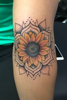 a woman's leg with a sunflower tattoo on the side of her thigh