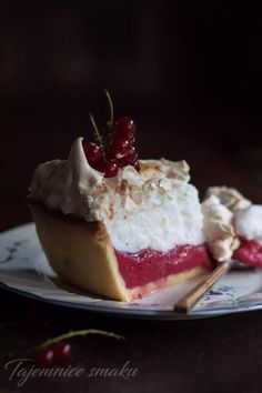 a piece of pie with whipped cream and cherries on top is sitting on a plate