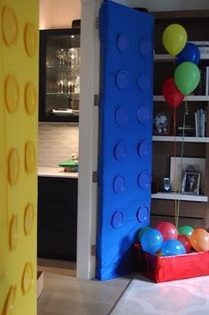 a room decorated in legos with balloons and bookshelves on the wall behind it