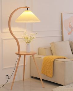 a living room with a couch, lamp and flowers on the table in front of it