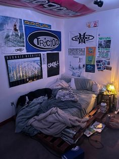 a bed sitting in the middle of a room with posters on the wall