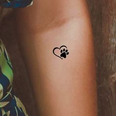 a woman's leg with a tattoo on it that has a dog paw in the shape of a heart