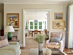 a living room filled with furniture and pictures on the wall above it's doorway