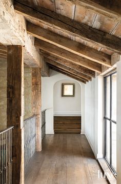 an empty room with wooden floors and beams