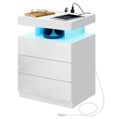 an electronic device is sitting on top of a white cabinet with blue light coming from it