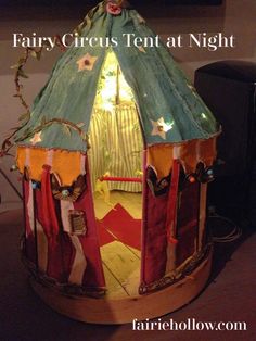 a tent that is sitting on top of a wooden floor with the words fairy circus tent at night written below it