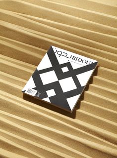 a book sitting on top of a wooden table next to a white and black object