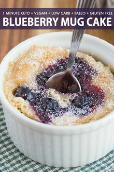 a blueberry mug cake in a white bowl with a spoon sticking out of it