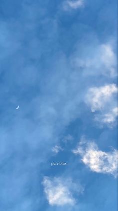 an airplane is flying through the blue sky with clouds in it's foreground