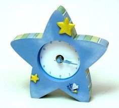 a blue clock with yellow stars on the face and bottom, sitting in front of a white background