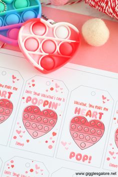 valentine's day printables and craft supplies on a pink table with hearts