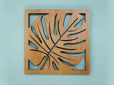 a wooden cutout of a leaf on a blue wall