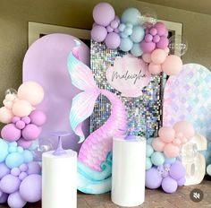 there are balloons and other decorations on the mantle for a mermaid themed birthday party at home