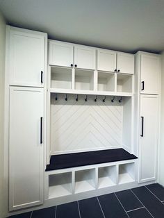 an empty room with white cabinets and black bench