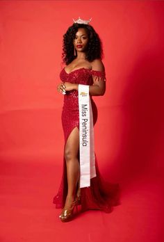 a woman in a red dress holding a sash