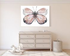 a pink butterfly on a white wall above a dresser