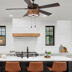 a kitchen with an island and ceiling fan