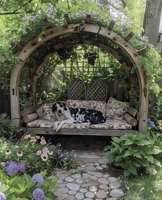 a black and white dog laying on top of a couch under a wooden gazebo