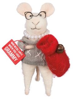 a stuffed animal wearing glasses and holding a red bag with a tag in it's hand