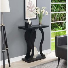 a black console table with flowers on it