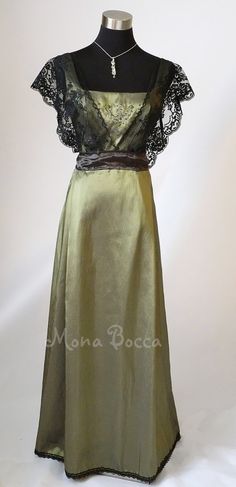 a dress with black lace on the top and green satin skirt, worn by mannequins