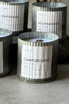 four round tin cans with labels on them