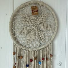 a white dream catcher hanging on the wall