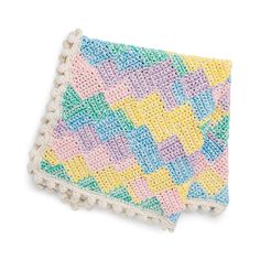 a multicolored crocheted dishcloth with pom - poms on it