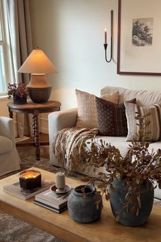 a living room filled with furniture and a lamp on top of a wooden coffee table